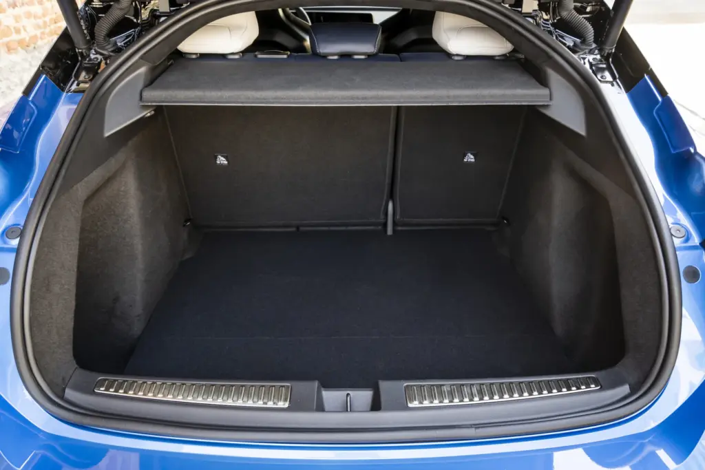 Blick in den geöffneten Kofferraum einer Alpine A390 GTS mit hoher Ladekante und umgeklappten Rücksitzen.