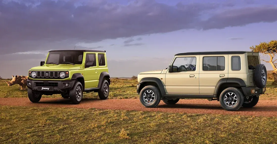 Zwei Suzuki Jimny-Modelle, ein Dreitürer in Grün und ein Fünftürer XL in Beige, auf einer Piste im Gelände