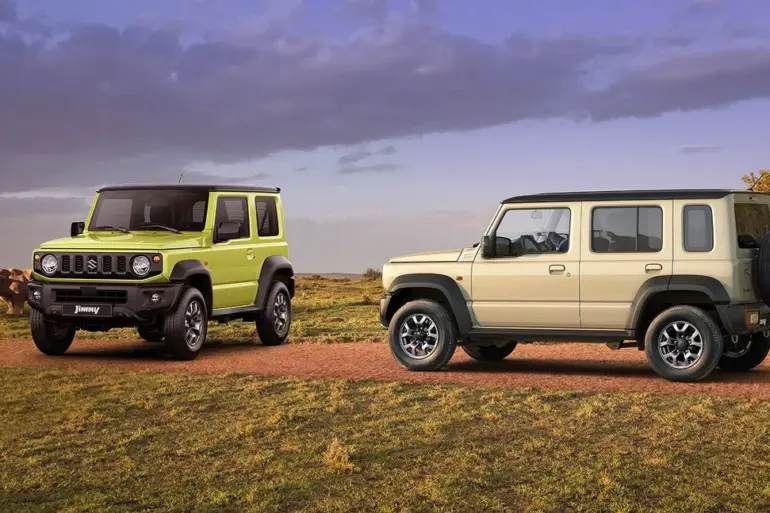 Zwei Suzuki Jimny-Modelle, ein Dreitürer in Grün und ein Fünftürer XL in Beige, auf einer Piste im Gelände