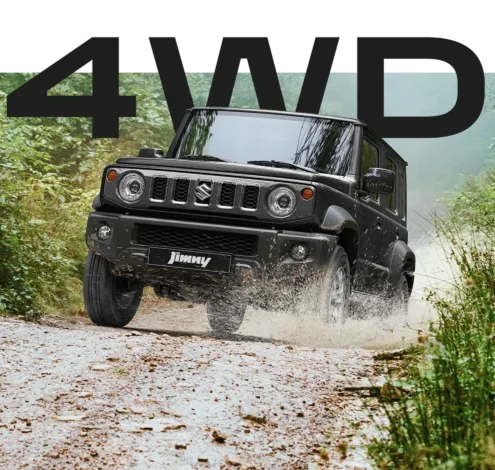 Suzuki Jimny 4WD fährt im Gelände über einen schlammigen Weg, vorn zu sehen.