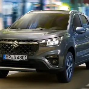 Frontansicht eines grauen Suzuki S-Cross auf einer urbanen Straße.