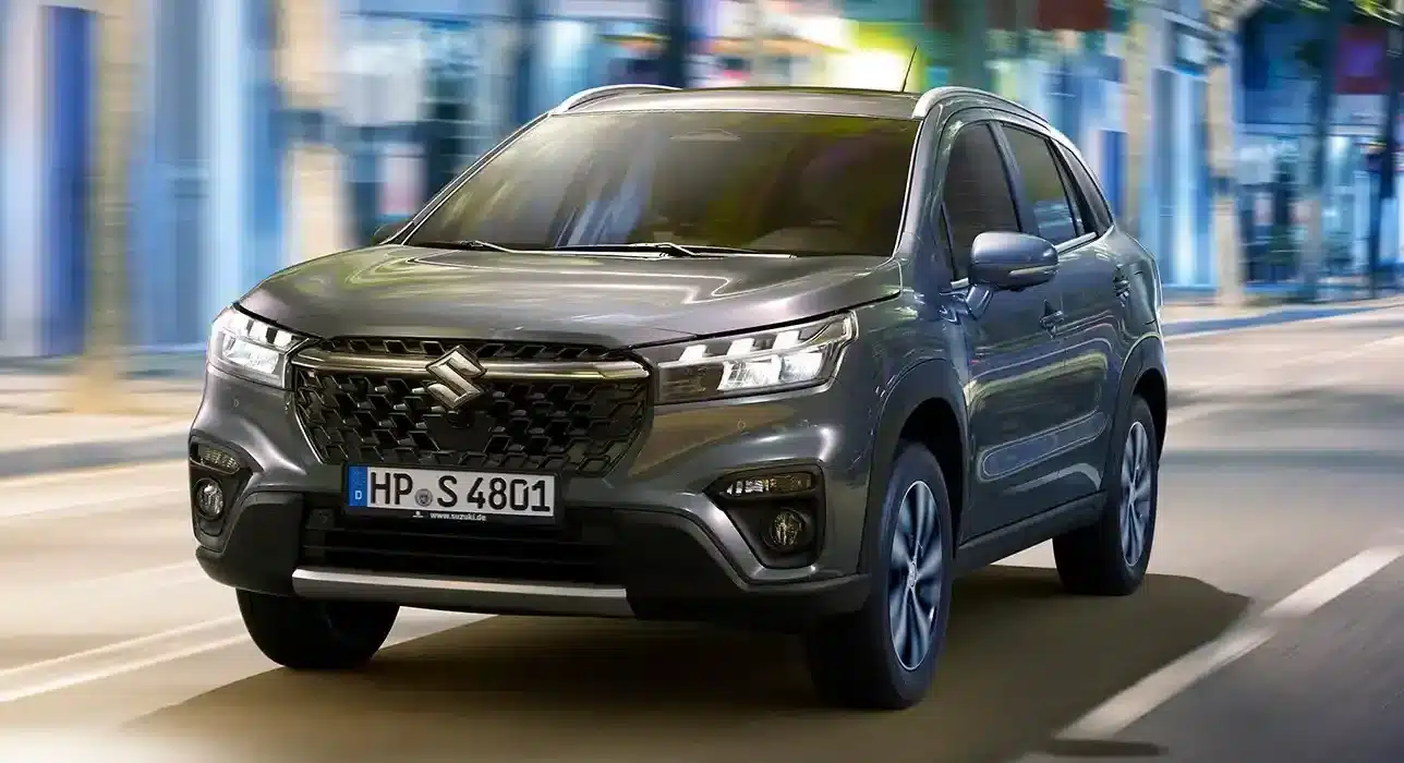 Frontansicht eines grauen Suzuki S-Cross auf einer urbanen Straße.