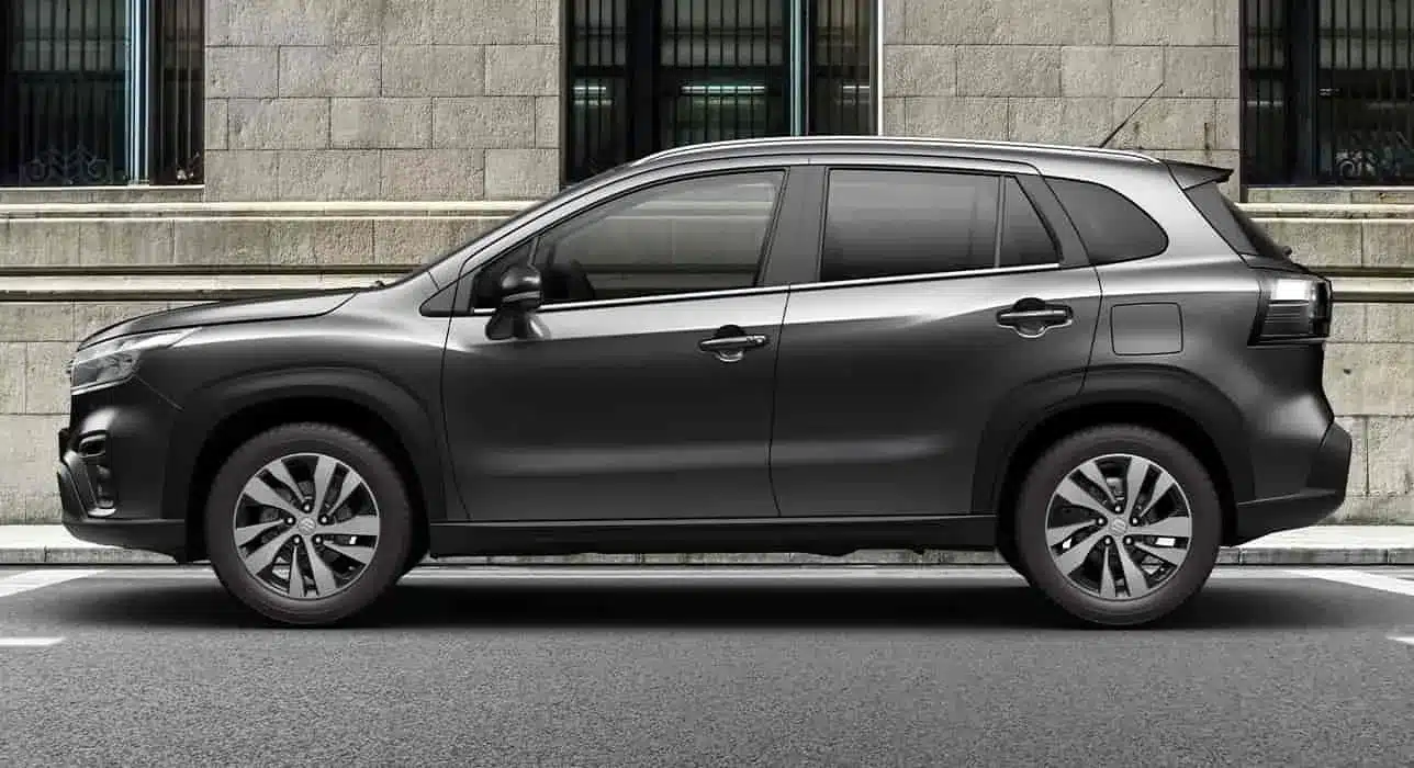 Suzuki S-Cross Kompakt-SUV, Seitenansicht, vor einer Steinmauer geparkt.