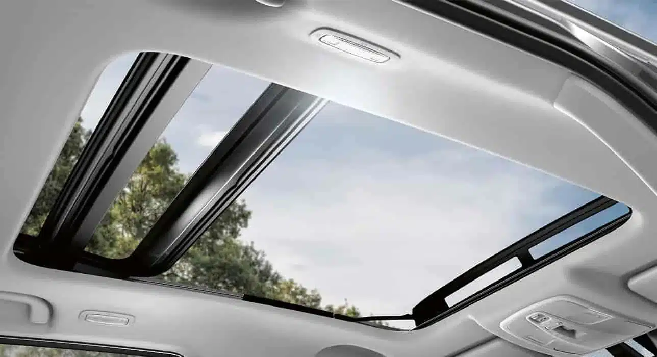 Blick aus dem Innenraum durch das geöffnete Panorama-Glasschiebedach eines Suzuki S-Cross