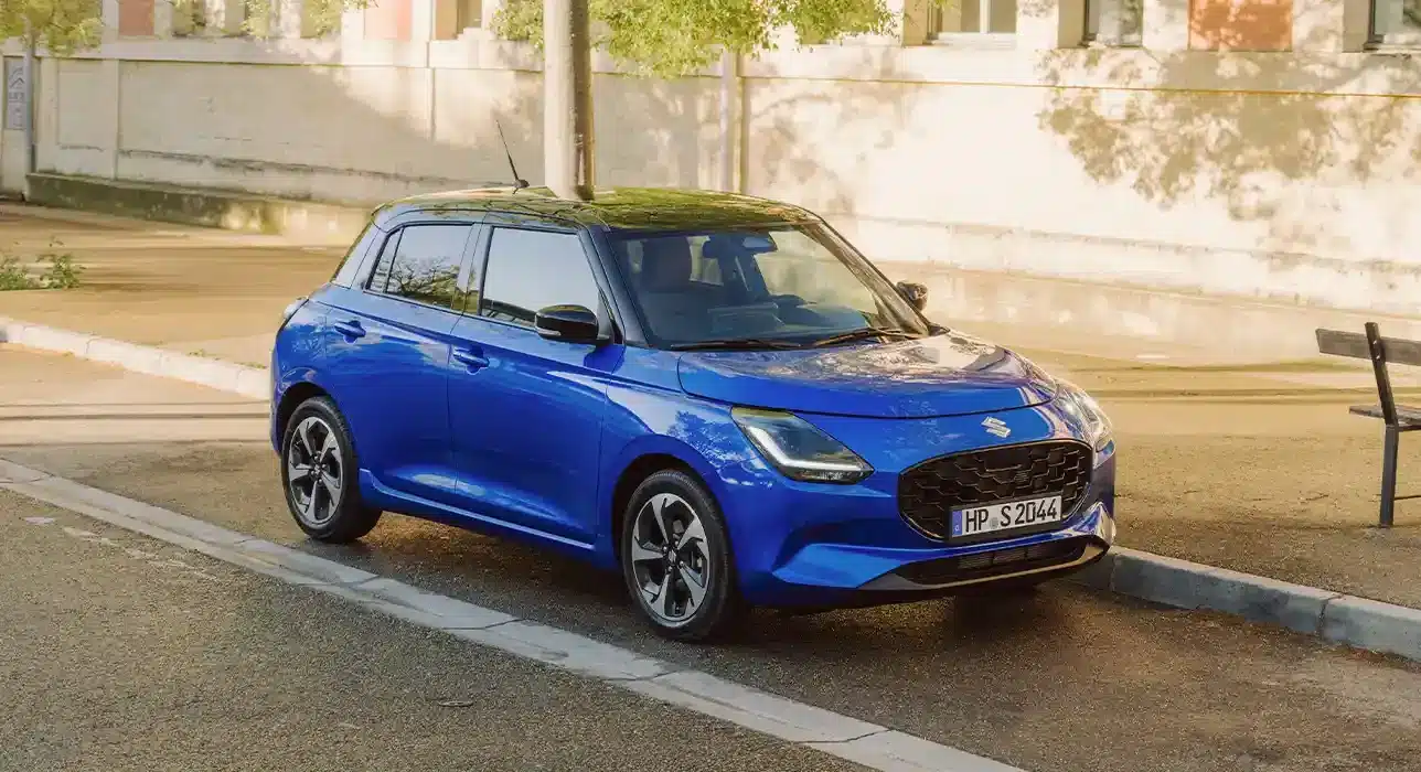 Blauer Suzuki Swift 2024 Modellgeneration parkt am Straßenrand bei Tageslicht