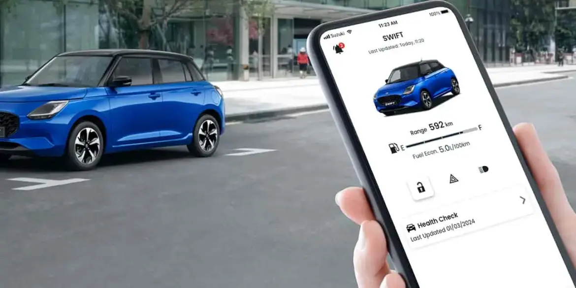 Suzuki Swift 2024 in Blau, im Vordergrund eine Hand mit Smartphone und Swift-App.