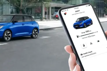 Suzuki Swift 2024 in Blau, im Vordergrund eine Hand mit Smartphone und Swift-App.