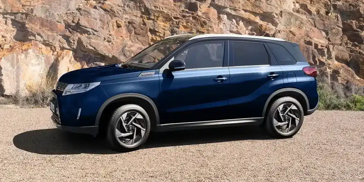 Blauer Suzuki Vitara X-ITE SUV, seitlich geparkt vor Felsen