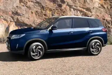 Blauer Suzuki Vitara X-ITE SUV, seitlich geparkt vor Felsen