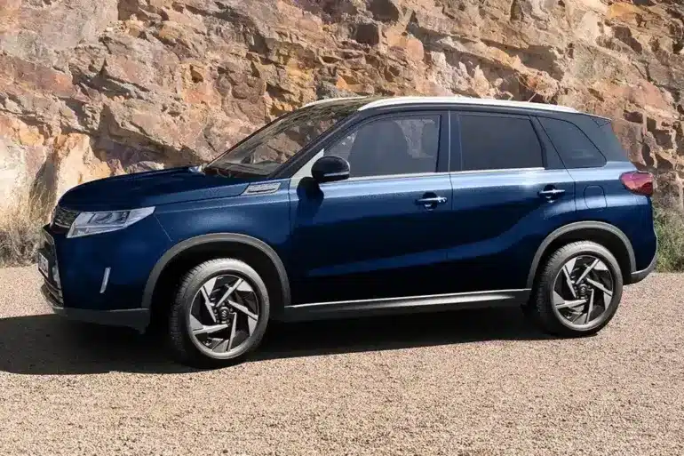 Blauer Suzuki Vitara X-ITE SUV, seitlich geparkt vor Felsen