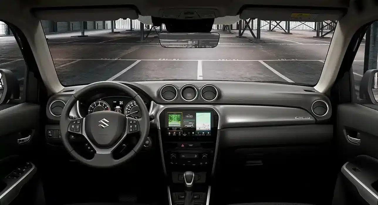 Blick in den Innenraum eines Suzuki Vitara mit Multifunktionslenkrad und 9-Zoll-Touchdisplay.