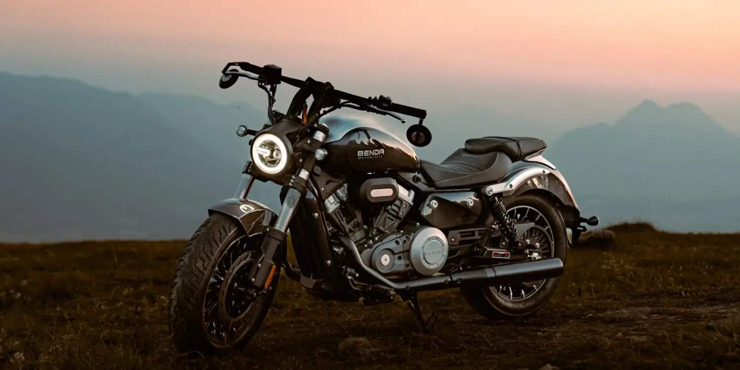 Benda Rock 300 Motorrad mit V2-Motor steht bei Sonnenuntergang auf einer Wiese vor Bergen