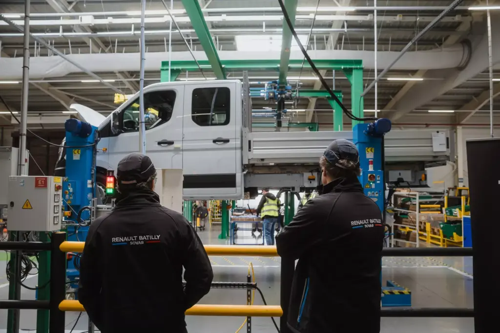 Renault Transporter bei der Umrüstung im Werk Batilly, überwacht von Werksmitarbeitern.