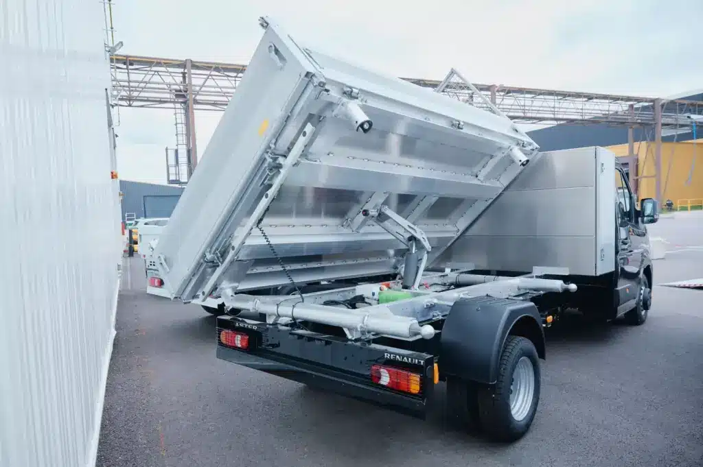 Renault Master als Dreiseitenkipper mit aufgeklappter Ladefläche auf einem Werksgelände.