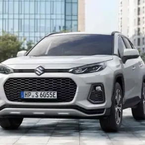 Suzuki Across Plug-in-Hybrid SUV aus der Frontperspektive, Weiß, steht auf einem Platz vor modernen Gebäuden.
