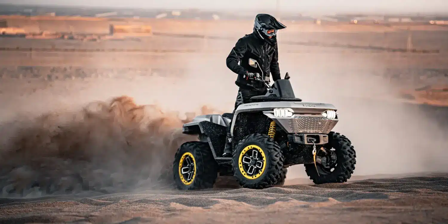 Redstone 550 ATV fährt in sandiger Landschaft und wirbelt Staub auf.