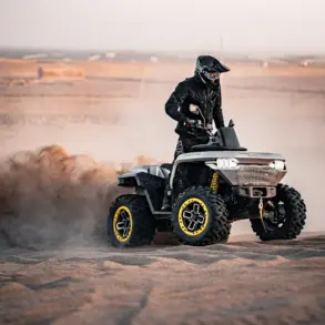 Redstone 550 ATV fährt in sandiger Landschaft und wirbelt Staub auf.