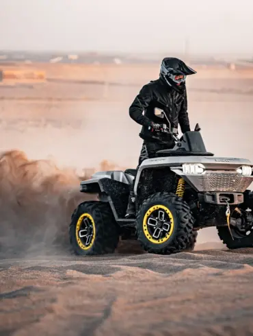 Redstone 550 ATV fährt in sandiger Landschaft und wirbelt Staub auf.