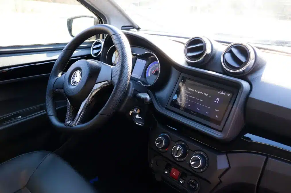 Innenraum und Armaturenbrett des Aixam E Coupé GTi mit Lenkrad, Belüftungsdüsen und Display