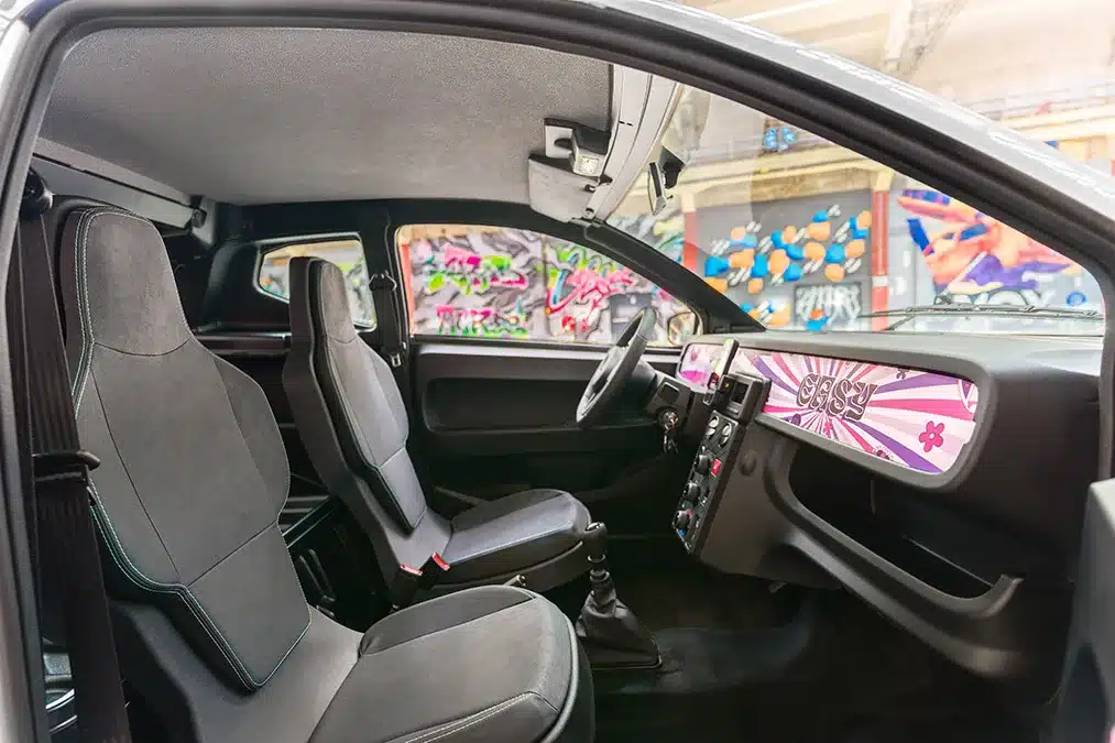 Innenansicht des Aixam Easy Access Diesel mit zwei Sitzen und bunt designtem Cockpitbereich.