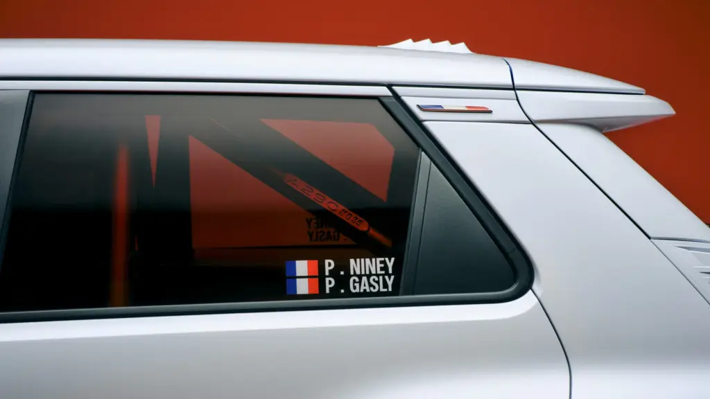 Seitlicher Blick auf die Rallye-Version des Alpine Lacoste A290 mit Überrollkäfig und Fahrernamen auf der Scheibe
