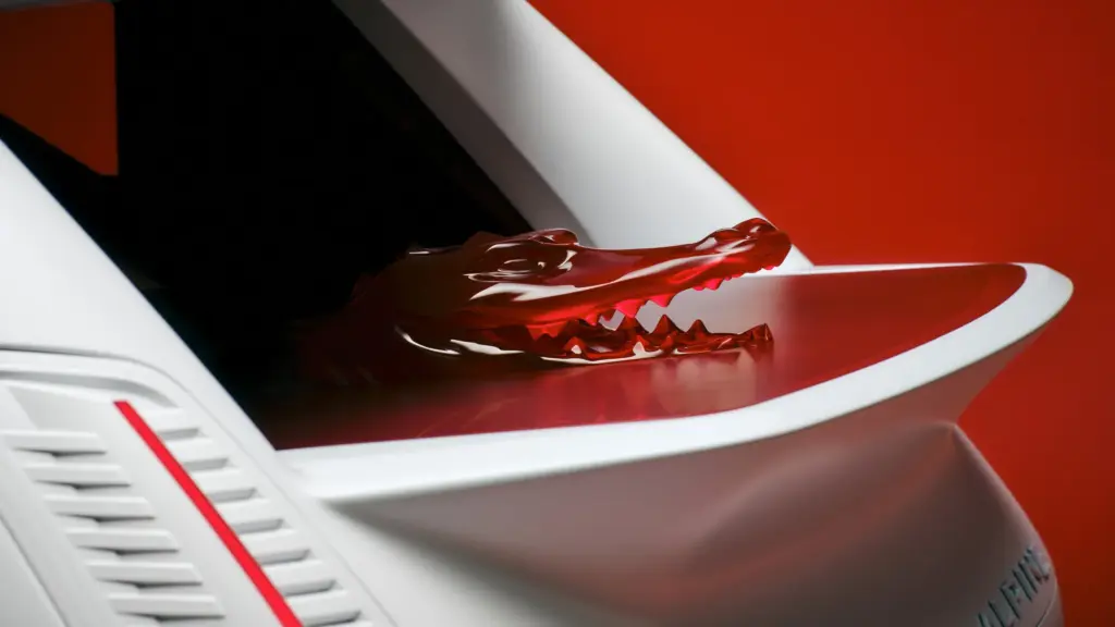 Rotes Krokodildetail auf dem Spoiler der Alpine Lacoste A290 Rallye vor rotem Hintergrund