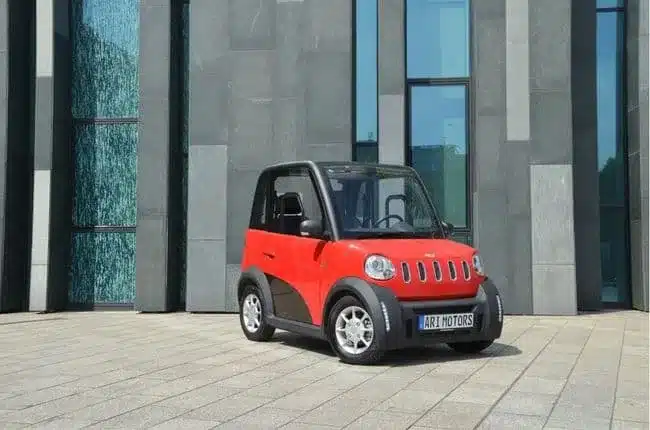 ARI 802 Elektrofahrzeug in Rot vor einem modernen Bürogebäude.