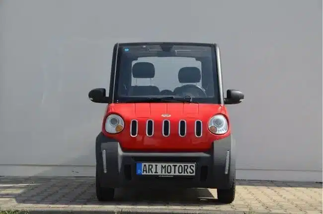 Frontansicht eines roten ARI 802 Elektrofahrzeugs von ARI Motors auf einem Parkplatz.