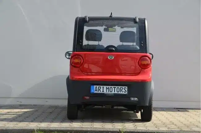 Heckansicht des ARI 802 Elektroautos auf einem Parkplatz vor einer hellen Wand