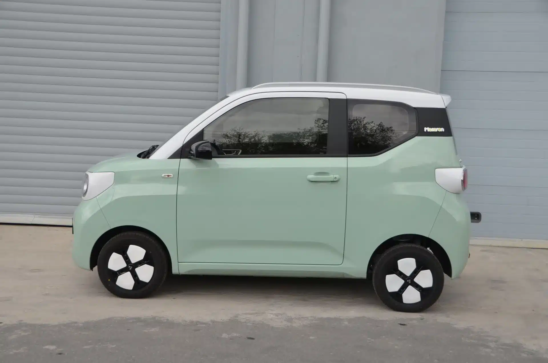 Seitenansicht eines mintgrünen ARI Bruni 2-Sitzers, eines kompakten Elektroautos für die Stadt