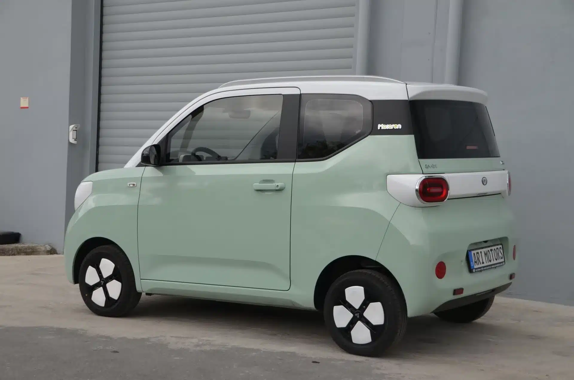ARI Bruni 2-Sitzer Elektroauto in mintgrüner Farbe vor einer Garage