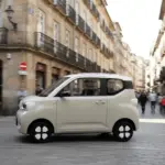 ARI Bruni Elektroauto fährt durch eine schmale Innenstadtstraße mit historischen Gebäuden.