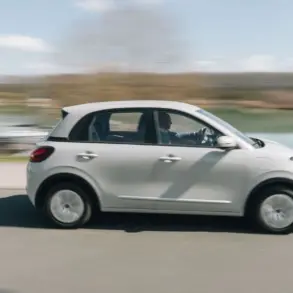 Seitenansicht des fahrenden ARI Poly Elektroautos in städtischer Umgebung