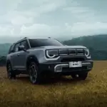 BAIC B30 SUV mit markantem Design und auffälligem Tagfahrlicht, stehend auf einem Feld vor bewaldeter Hügelkulisse.
