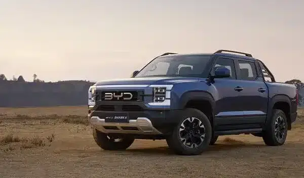 BYD Shark 6 Pickup steht auf einer staubigen Fläche im Freien