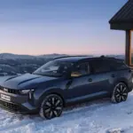 Dacia Striker bei Sonnenuntergang in verschneiter Berglandschaft vor moderner Hütte