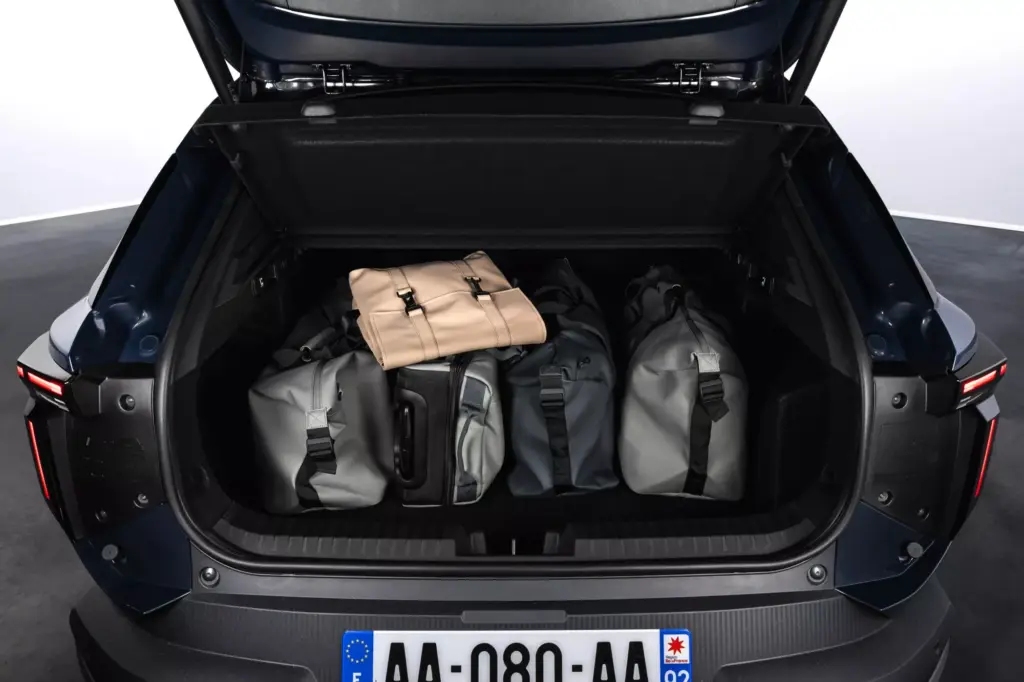 Blick in den geöffneten Kofferraum des Dacia Striker, gefüllt mit mehreren Reisetaschen.