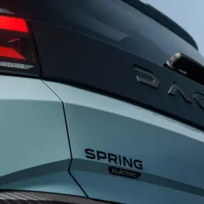 Nahaufnahme vom Heck des vollelektrischen Dacia Spring mit leuchtendem Rücklicht und Modellschriftzug