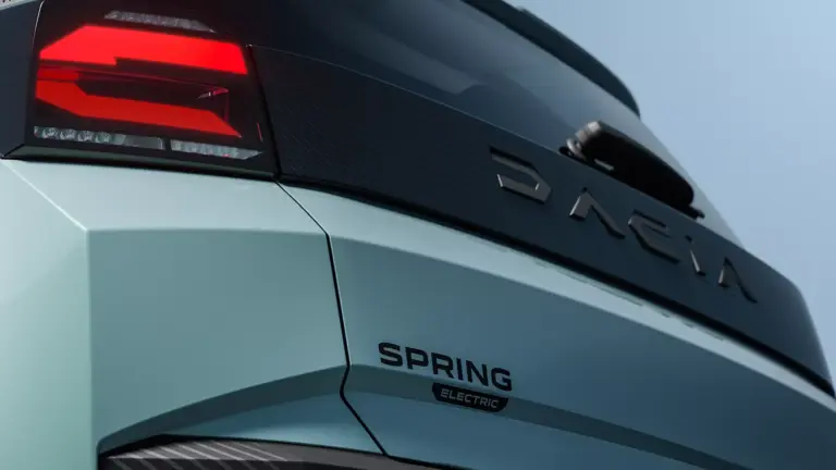 Nahaufnahme vom Heck des vollelektrischen Dacia Spring mit leuchtendem Rücklicht und Modellschriftzug