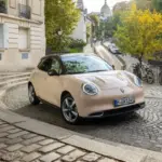 GWM ORA 03 Kompakt-Elektroauto in einer europäischen Stadt auf Kopfsteinpflaster