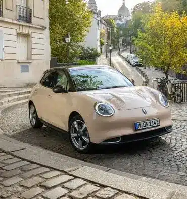 GWM ORA 03 Kompakt-Elektroauto in einer europäischen Stadt auf Kopfsteinpflaster