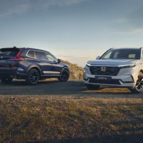 Zwei Honda CR-V der aktuellen Generation, einer von vorne und einer von hinten, auf einem Feldweg bei Sonnenuntergang.