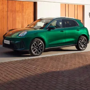 Grüner GWM ORA 5 SUV seitlich vor einer Holzfassade geparkt