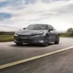 Honda Prelude 2025 in Meteoroid Grey Metallic fährt dynamisch auf einer kurvigen Straße.