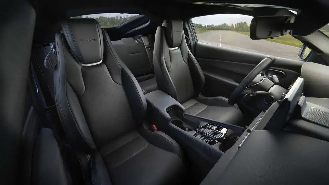 Innenraum des Honda Prelude mit zwei Sportsitzen aus schwarzem Leder, Armlehne und modernen Bedienelementen.