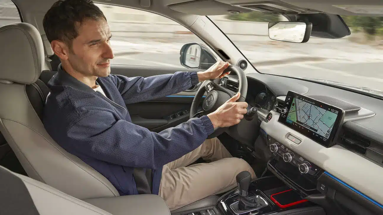 Blick in den Innenraum des Honda HR-V e:HEV mit Fahrer, modernem Cockpit und großem Display.