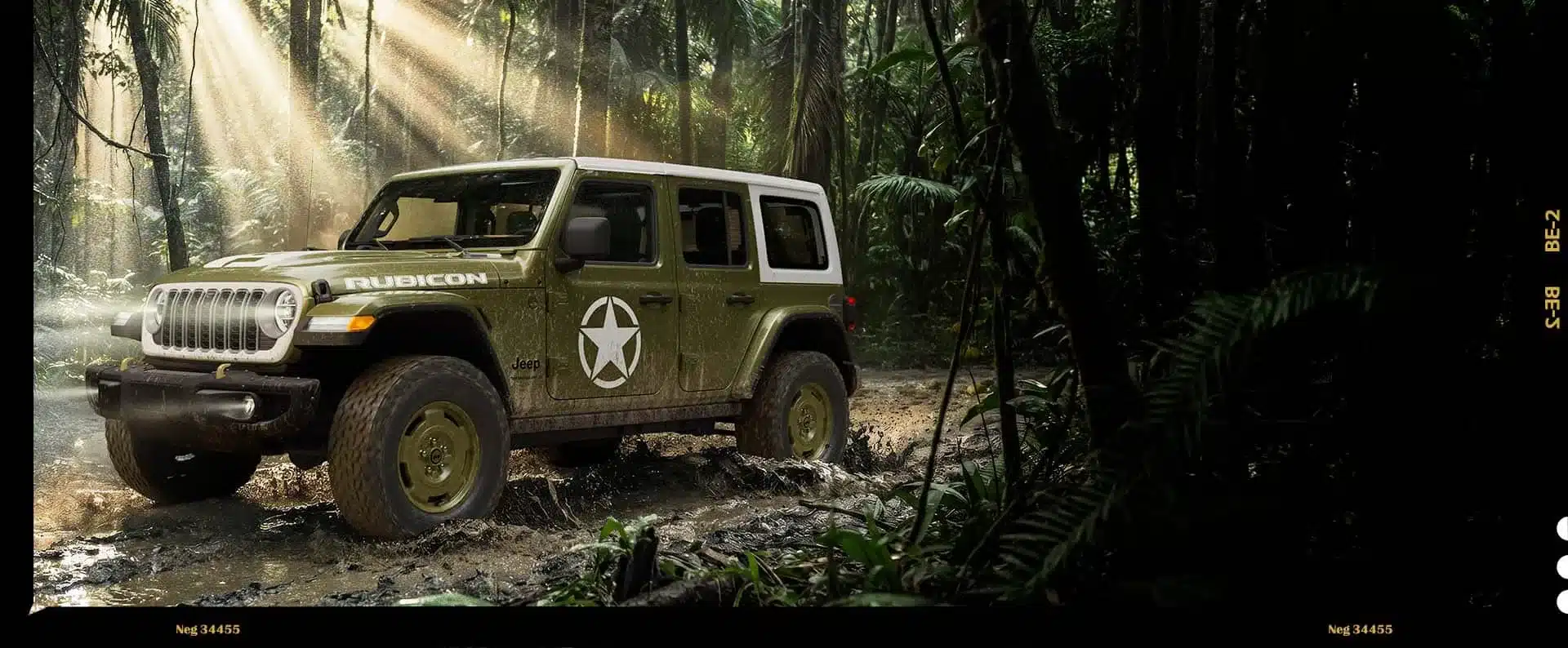 Jeep Wrangler Sarge 2026 mit olivgrüner Lackierung, weißem Dach und markantem Stern an der Tür im schlammigen Gelände.