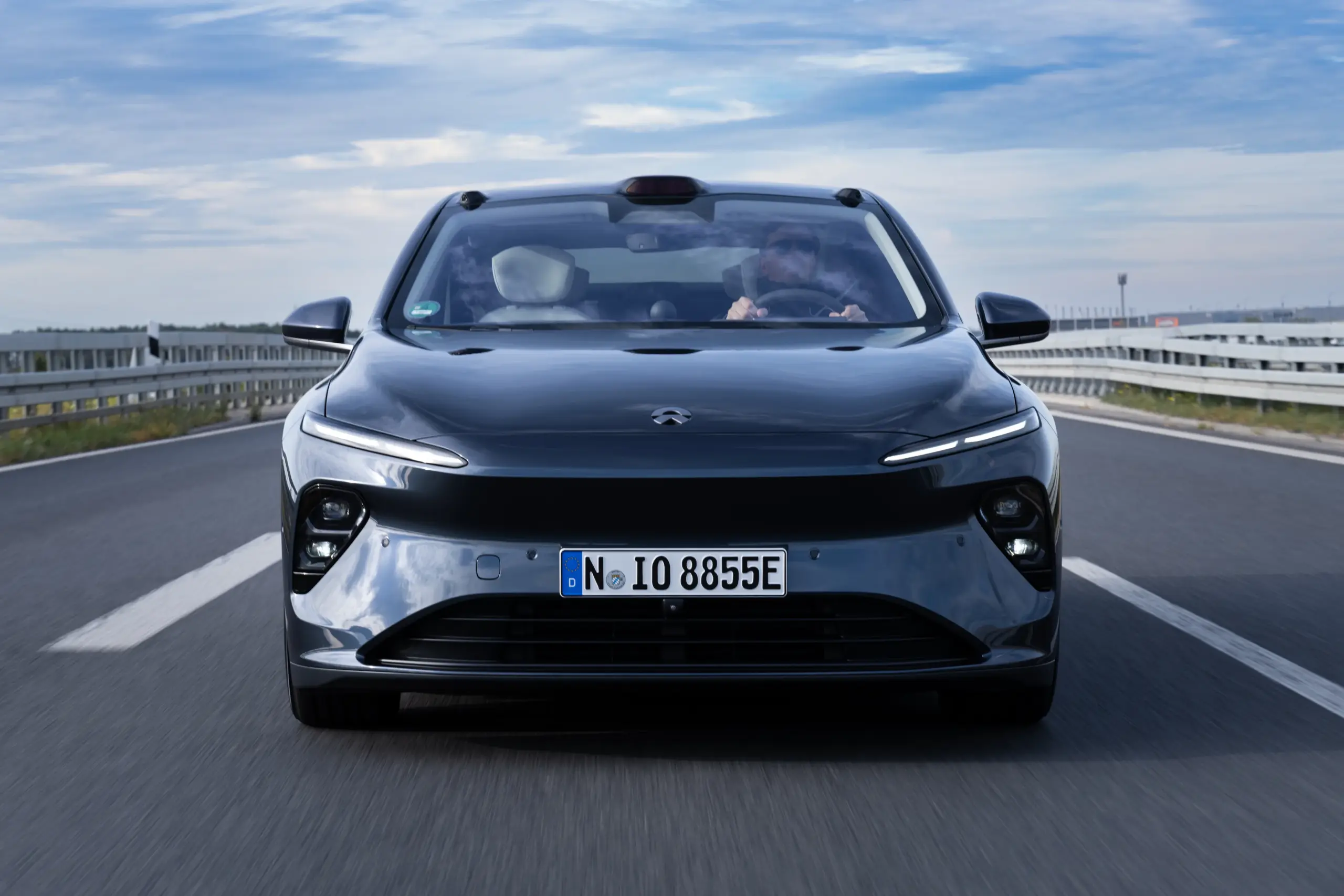 Frontalansicht eines fahrenden NIO ET7 auf einer deutschen Autobahn, moderner elektrischer Limousine mit markanter Front und LED-Lichtsignatur.