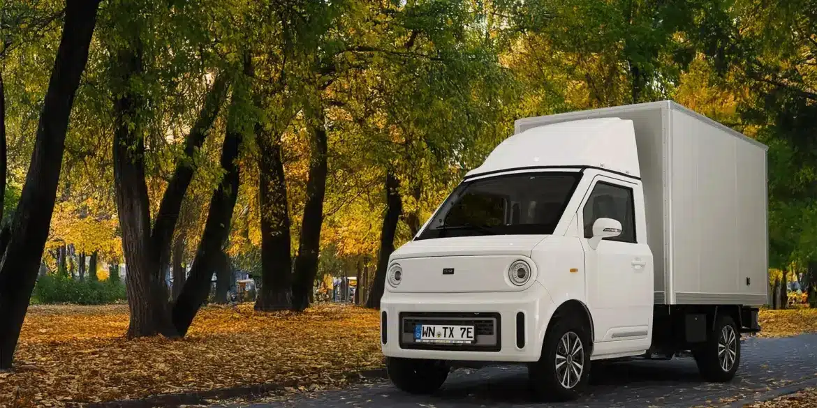 Weißer TYN-e TX7 Elektro-Transporter steht auf einer von Bäumen gesäumten Allee im Herbst.