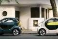 Zwei XEV YOYO PRO Stadtautos in verschiedenen Farben auf einer Straße vor einem Gebäudeeingang